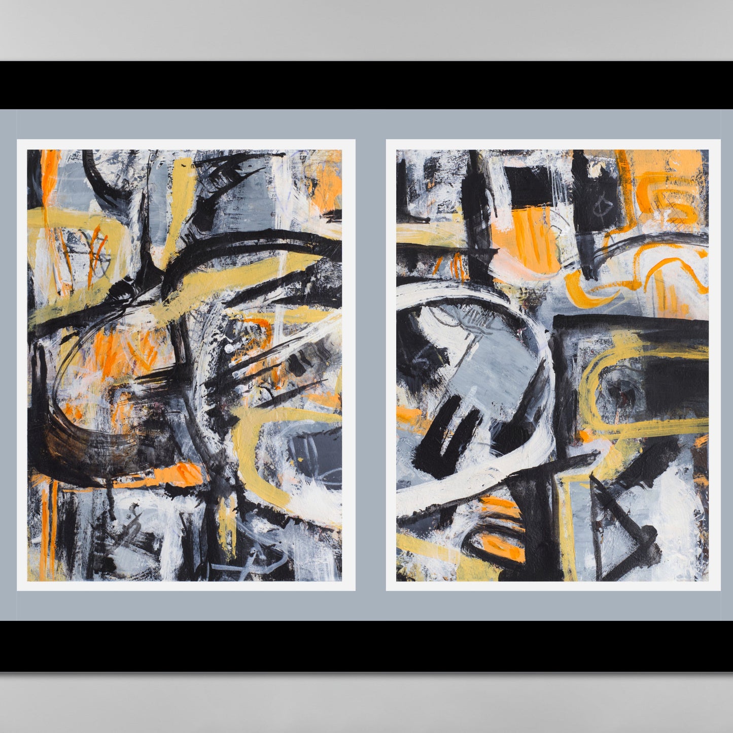 Close up of Two abstract artworks in a black frame on a gray background