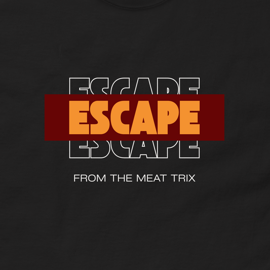 A close-up of a black t-shirt featuring a graphic design. The design displays the word 'ESCAPE' in orange letters inside a dark red rectangular block, layered over a white and black outline of the word 'ESCAPE' behind it, with the text 'FROM THE MEAT TRIX' printed in white below.