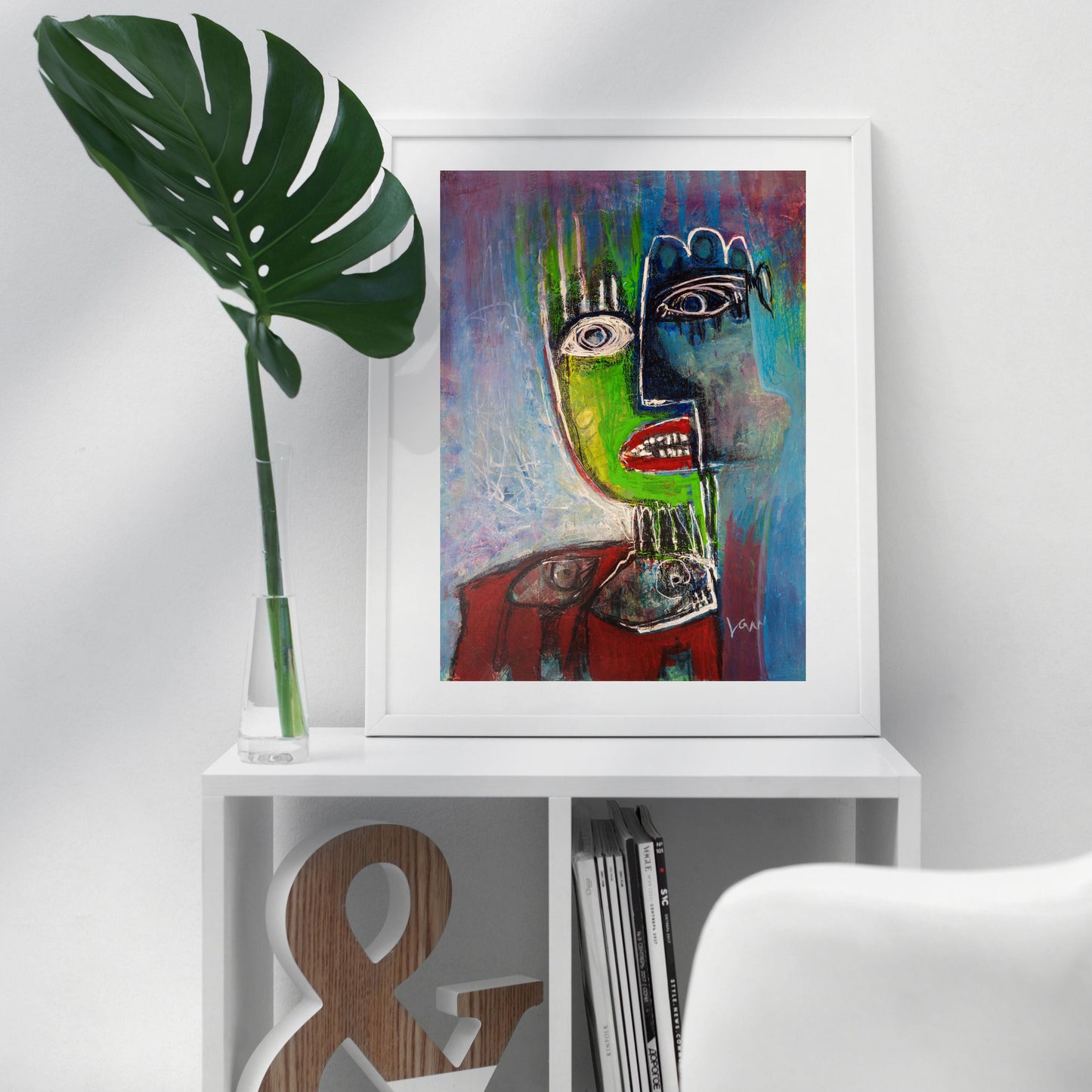 Colorful original abstract Fish Face artwork framed on a white shelf with decorative elements