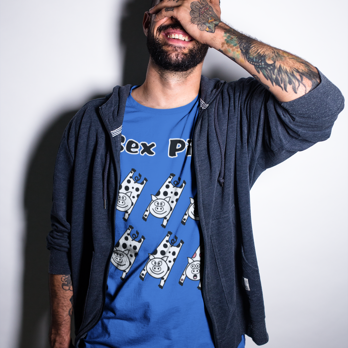 Man wearing a blue t-shirt with graphic design and text, standing against a plain background