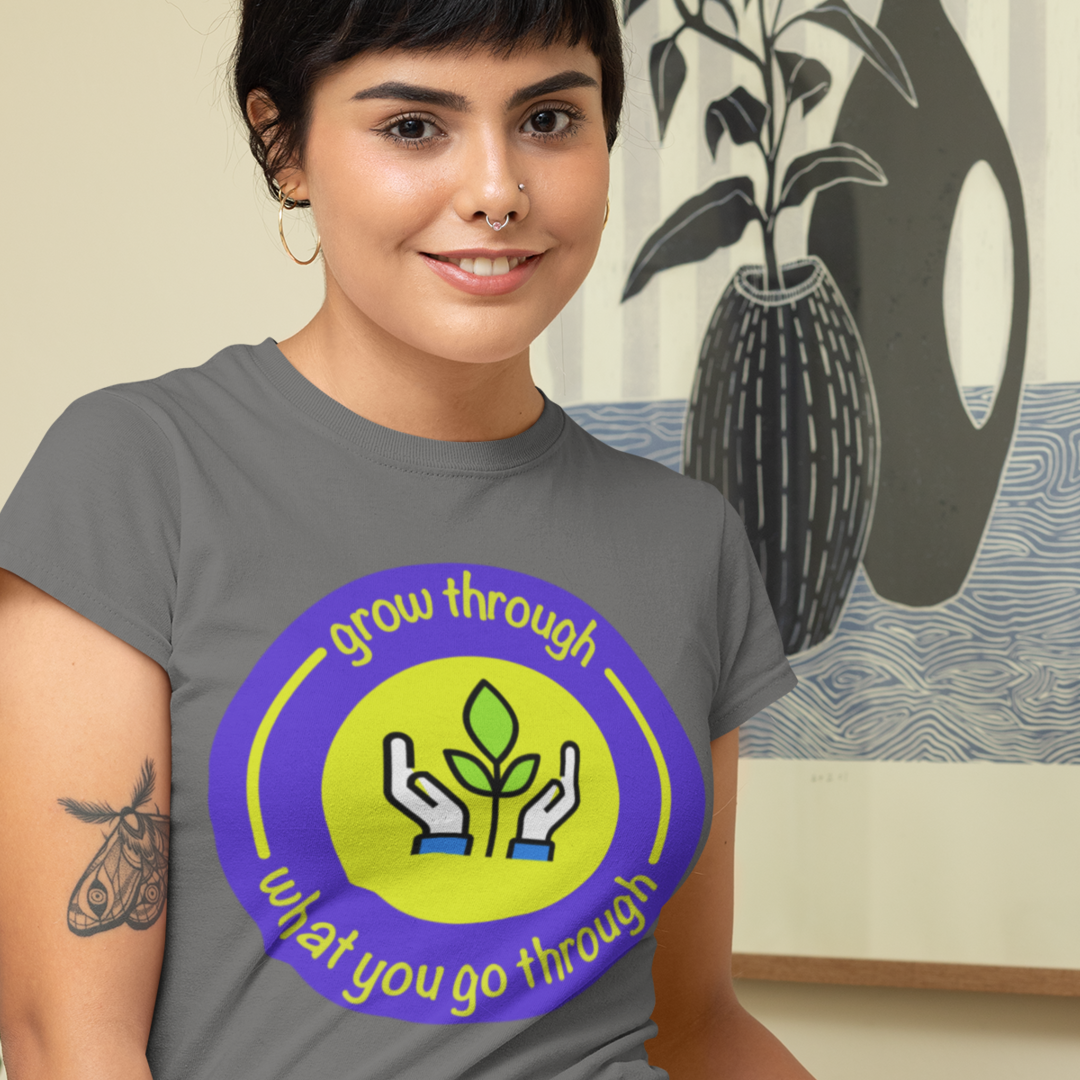 Woman wearing a gray t-shirt with a motivational graphic and text.