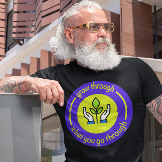 Man wearing a black t-shirt with a motivational quote and graphic design, standing outdoors.