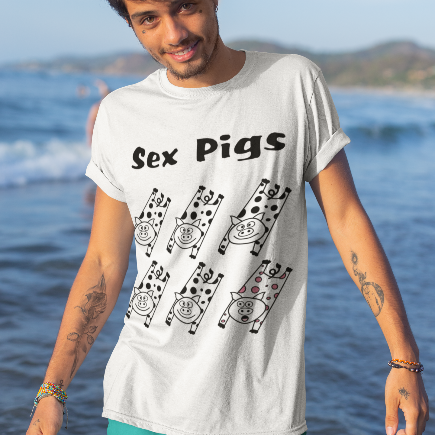 Man wearing a white t-shirt with 'Sex Pigs' design on a beach
