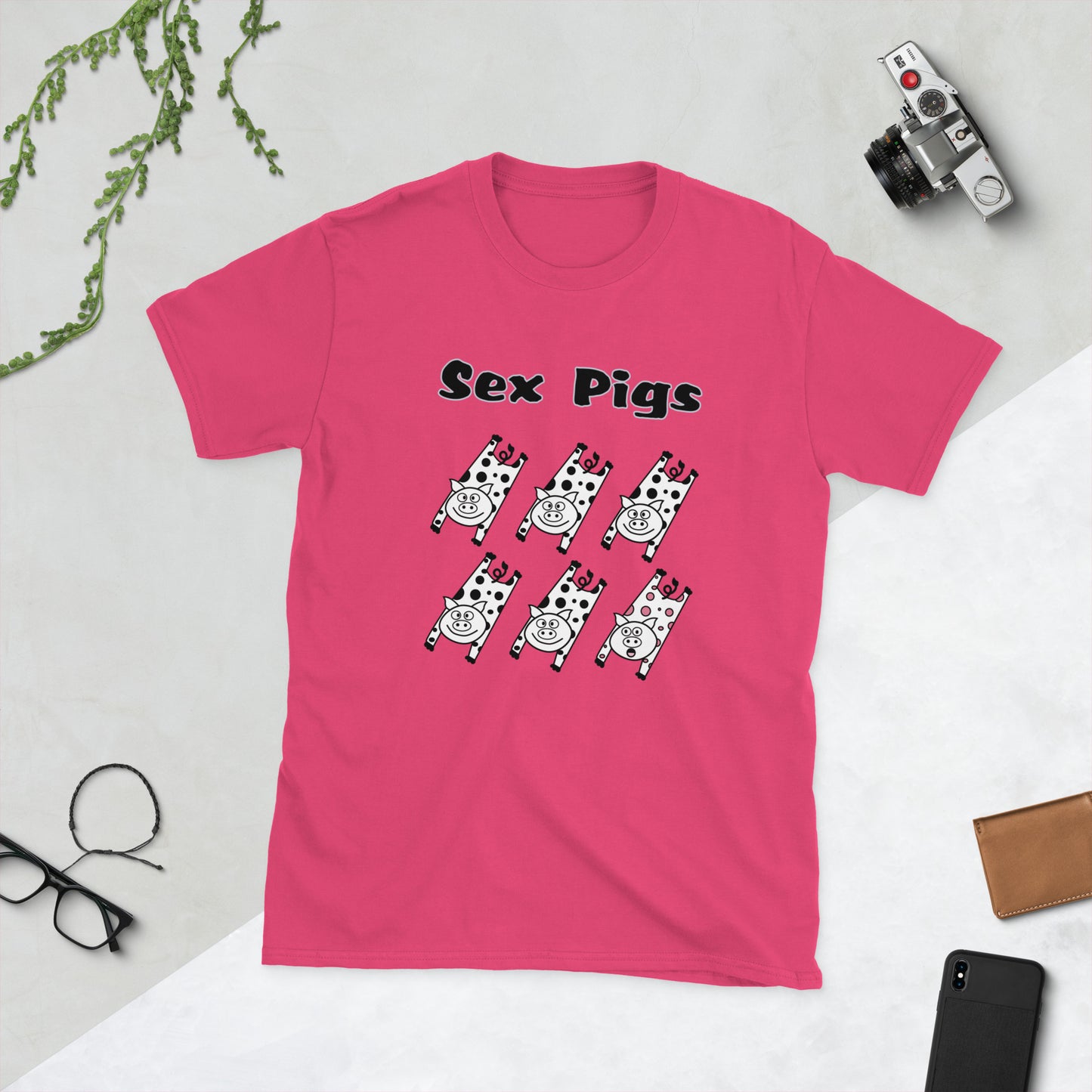 Pink t-shirt with 'Sex Pigs' graphic design on a light gray surface.