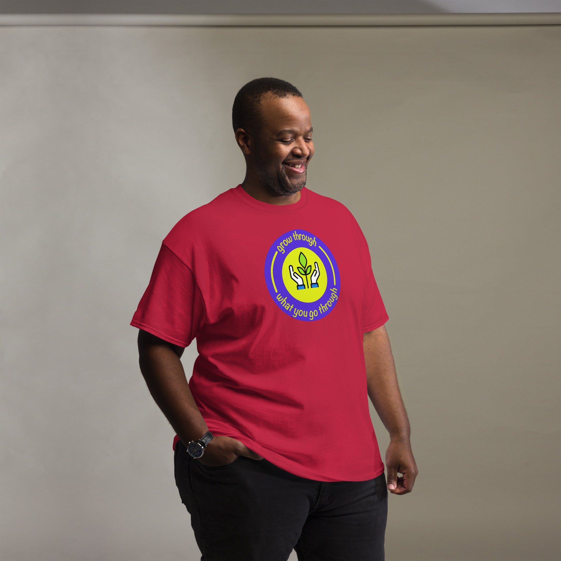 Man wearing a red t-shirt with a logo on a plain background