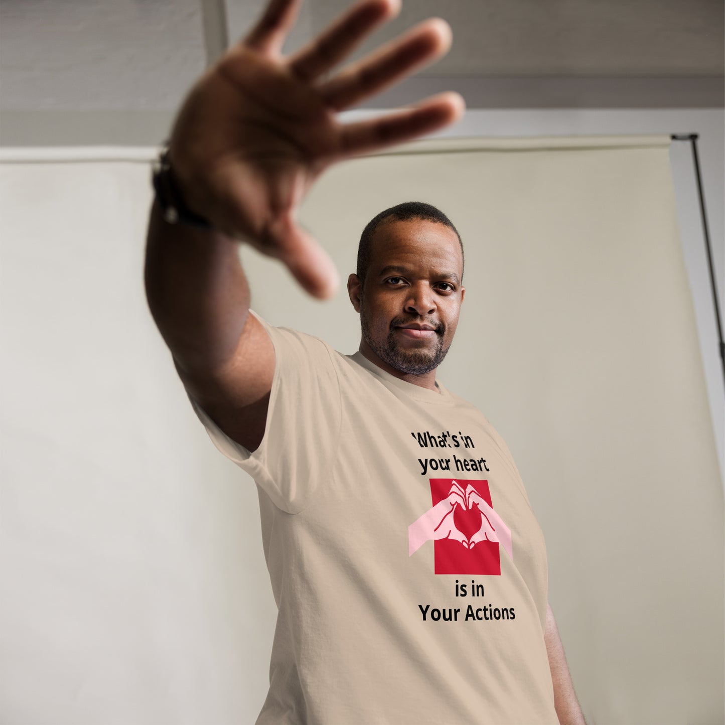 Man wearing a t-shirt with a motivational message and reaching out with his hand.