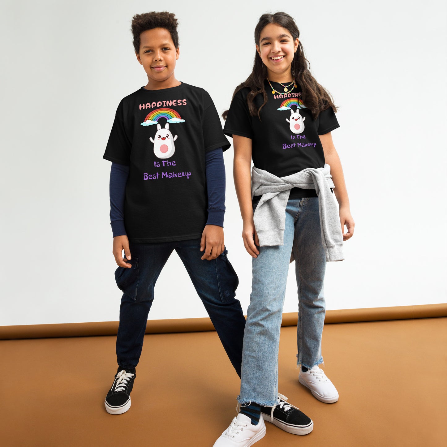 Two children wearing black t-shirts with colorful designs on a plain background